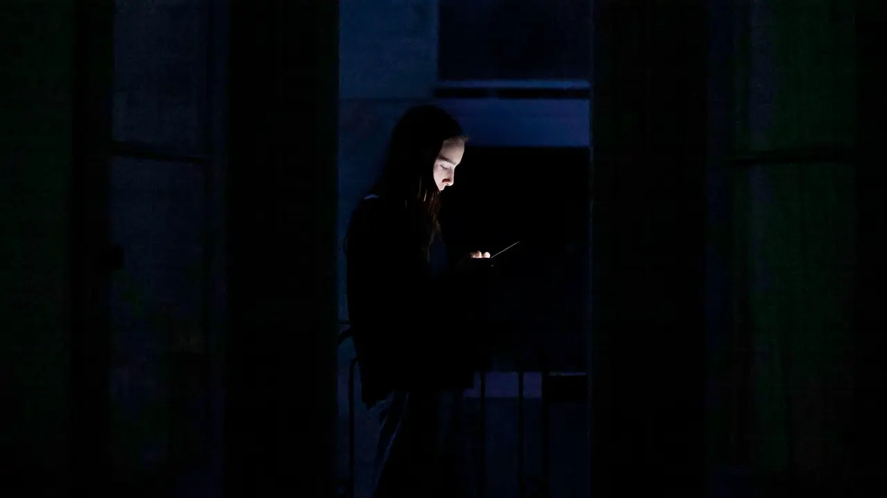 Una joven con su tel&eacute;fono m&oacute;vil el d&iacute;a del apag&oacute;n / EFE