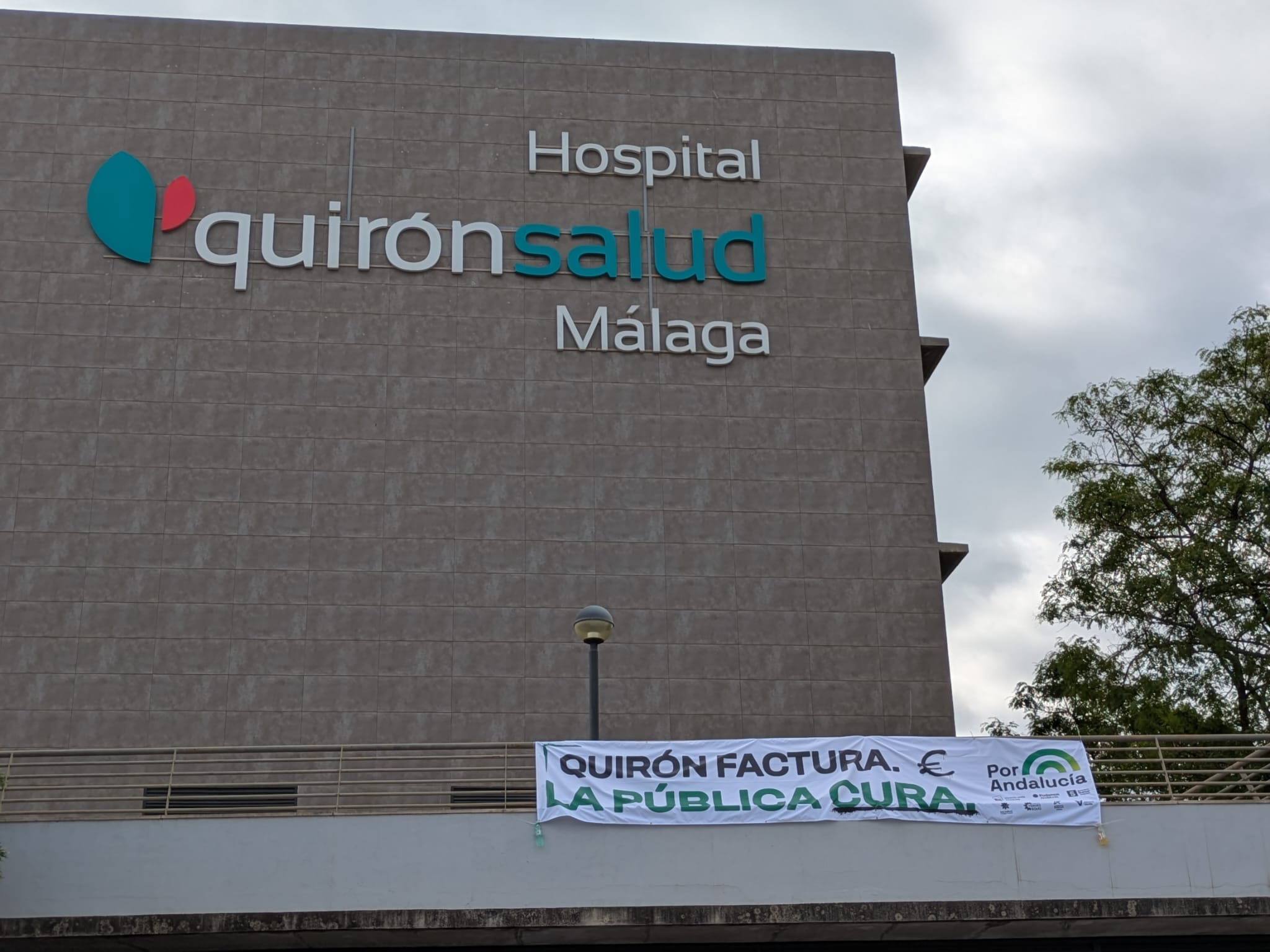 Por Andalucía coloca una pancarta en el edificio de Quirón Salud en Málaga / Samuel Saborido